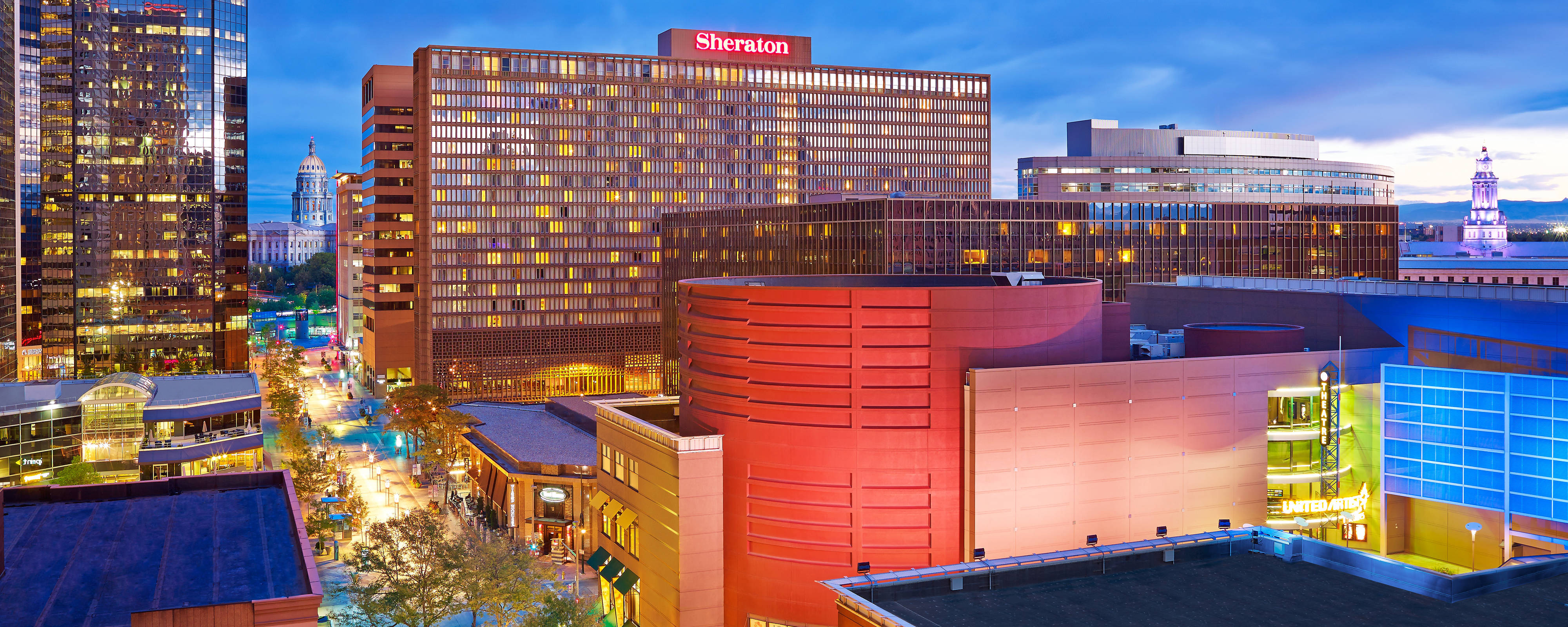 Sheraton hotel in lit up skyline at dusk