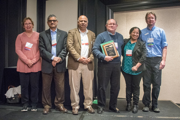 Committee members and award winner with plaque