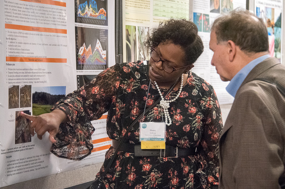 Woman discussing her poster with man at 2018 Symposium