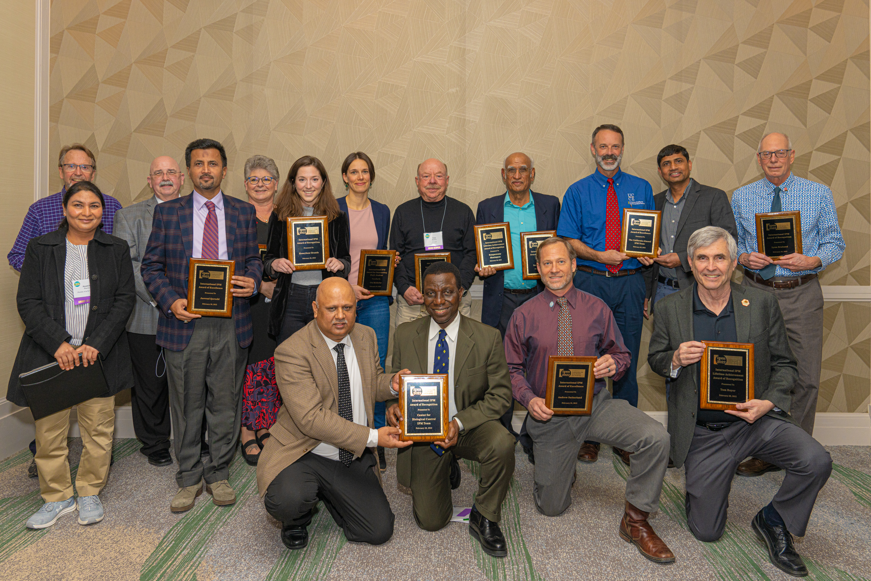 Diverse group of IPM award recipients posing with their plaques